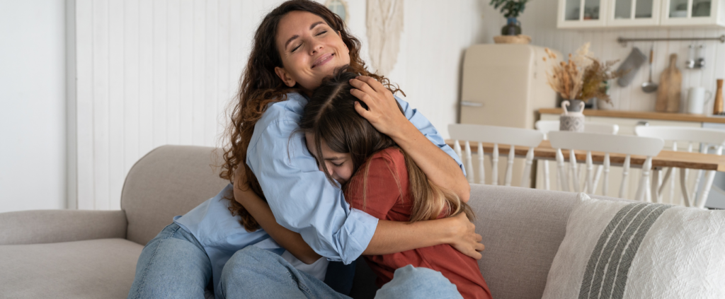 parent hugging child on couch