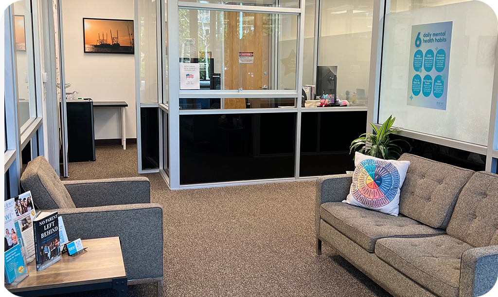 Lobby area with grey couches and reception desk.